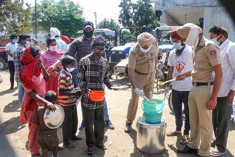 पंजाब पुलिस के जवान भोजन वितरित करते हुए।
