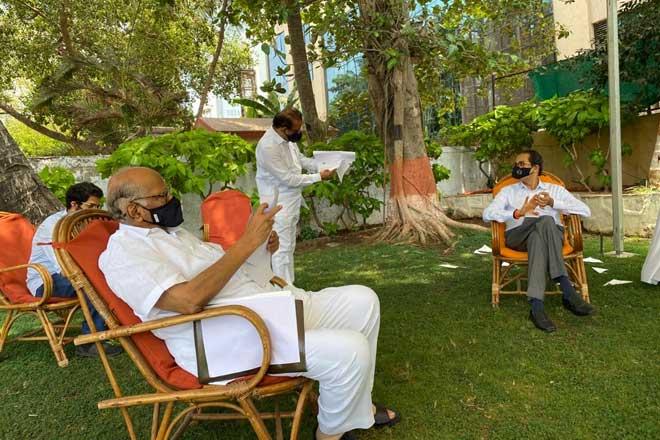 शरद पवार और उद्धव ठाकरे बात करते हुए।