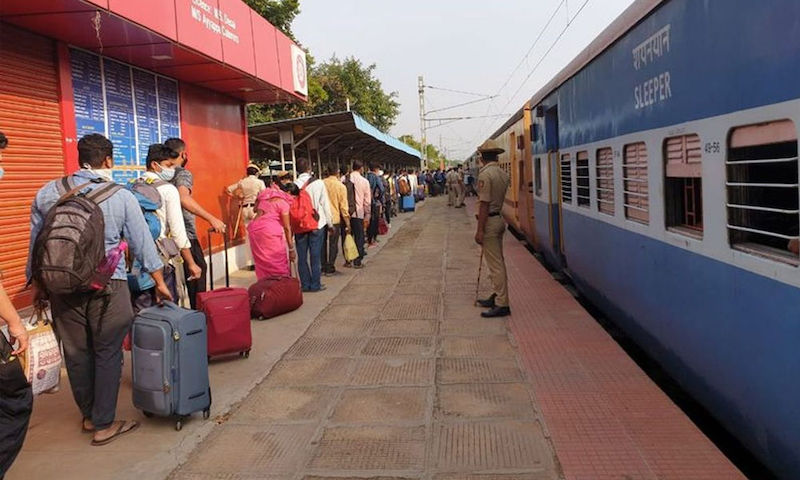 ट्रेन से घरों को लौटते प्रवासी मज़दूर।