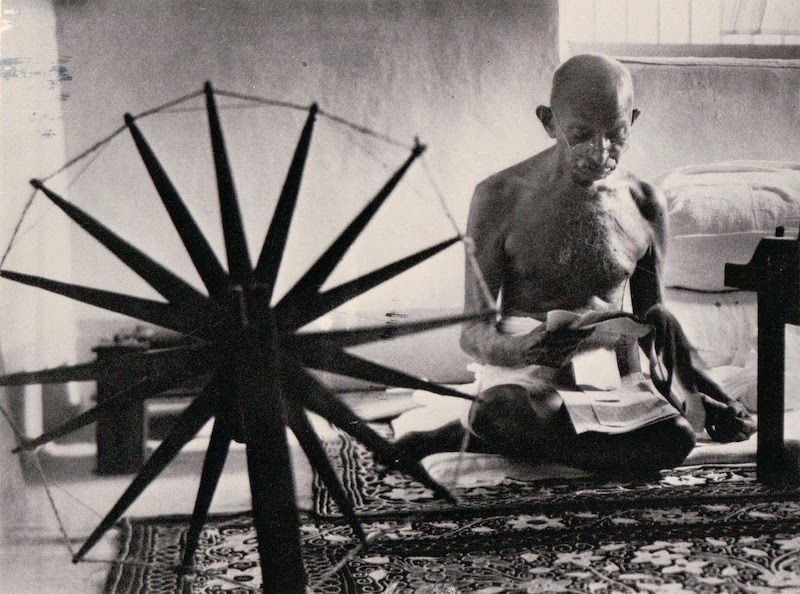 गांधी चरखे पर सूत कातते हुए।