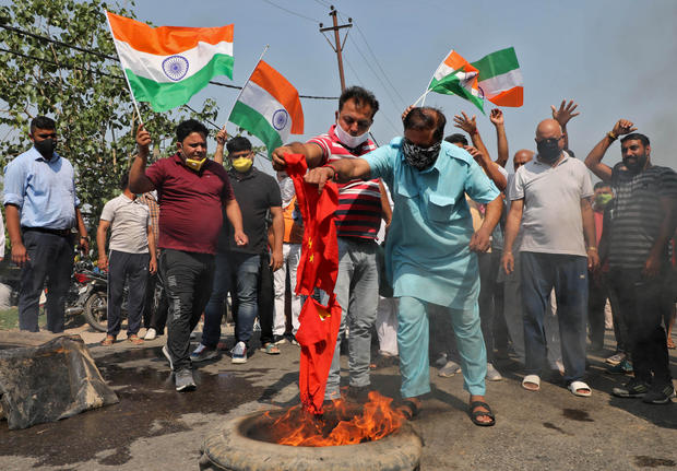 चीन का झंडा जलाते लोग।